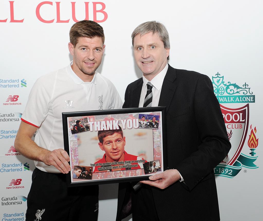 Liverpool Echo editor John Thompson presents Steven Gerrard with a picture created by an 8-year-old using Windows 95 on behalf of the media. (@LFC)