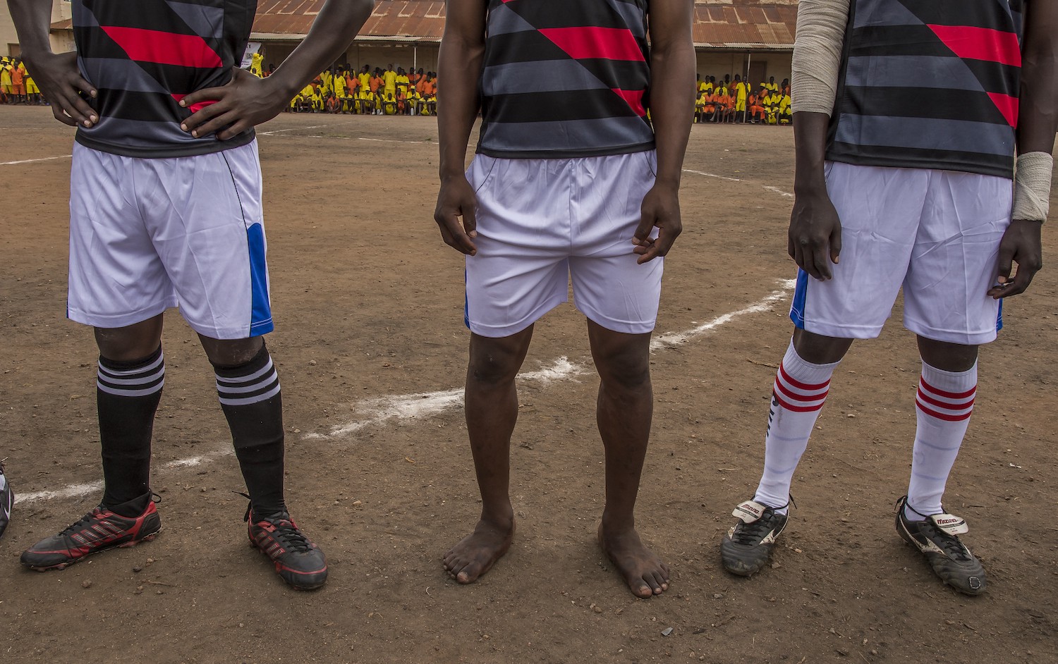 In Luzira Prison, in Kampala, a football league is organized. The teams composed of inmates meet each other throughout the year until a final. The teams are named mainly out of English Premier League clubs: Manchester United, Liverpool, Everton, ... The pitch is the courtyard of the Upper Prison, the most secure place of the Prison large compound. Hundreds of inmates come to support their favorite team. A Liverpool player plays the final barefoot.